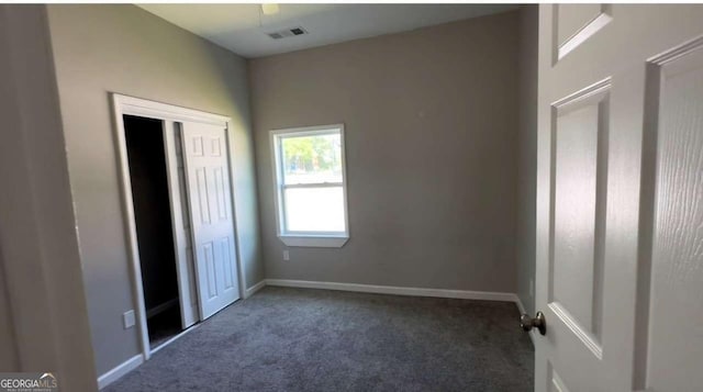 50 Ivy St, Porterdale, GA 30014 - unfurnished bedroom with a closet, baseboards, carpet flooring, and visible vents