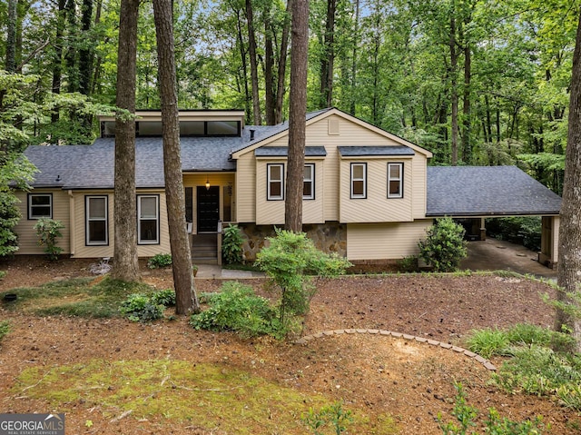 tri-level home with a shingled roof and an attached carport