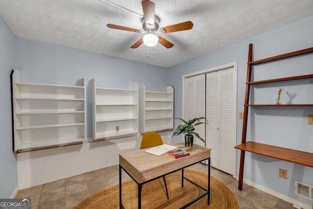office space with visible vents, a textured ceiling, baseboards, and ceiling fan