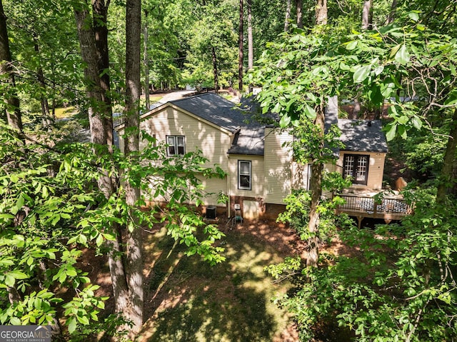 exterior space with a deck and roof with shingles