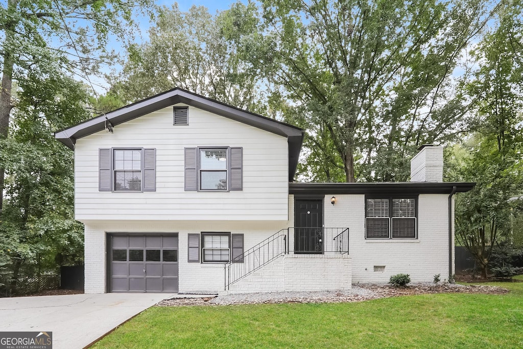 1590 SW Cherry Hill Ln, Conyers, GA 30094 - split level home featuring brick siding, driveway, a front lawn, and a garage