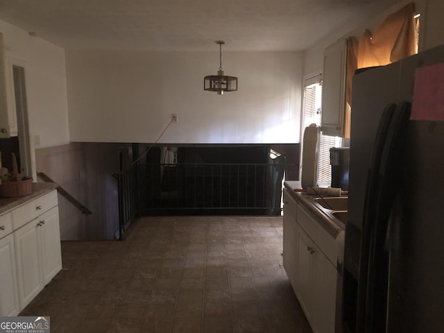 2017 Pine Cone Dr SW, Atlanta, GA 30331 - kitchen featuring black refrigerator with ice dispenser, white cabinets, wainscoting, and hanging light fixtures