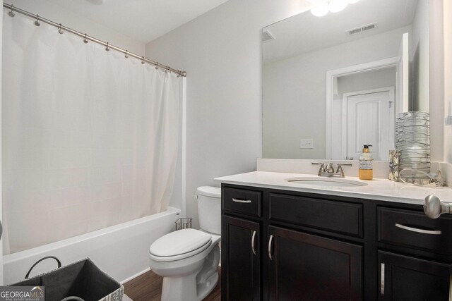 bathroom with vanity, toilet, shower / bath combination with curtain, wood finished floors, and visible vents