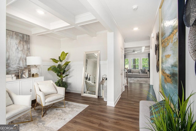 sitting room with crown molding, ceiling fan, wood finished floors, and beamed ceiling