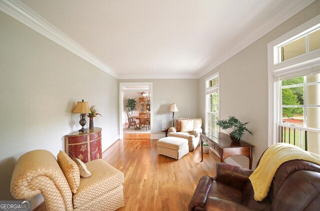living area with plenty of natural light, crown molding, and wood finished floors