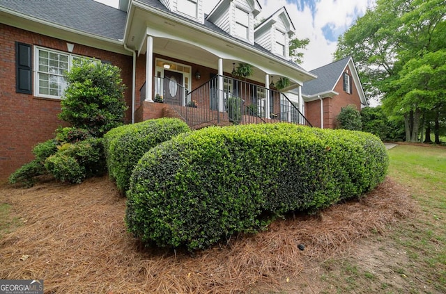 view of side of property with brick siding and a shingled roof