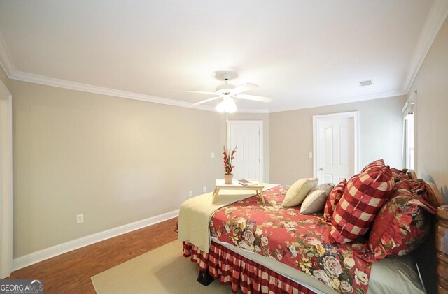 bedroom featuring baseboards, ornamental molding, a ceiling fan, and wood finished floors