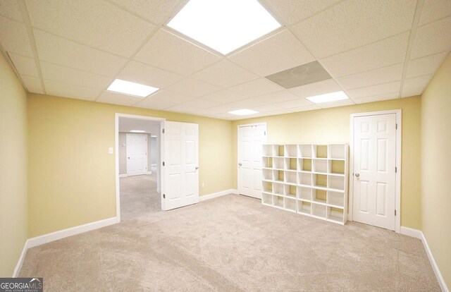 unfurnished room featuring baseboards, carpet, and a paneled ceiling