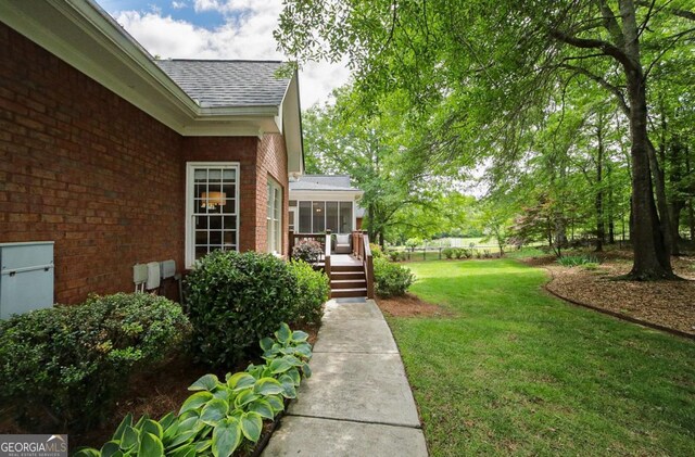 view of yard with a wooden deck and a sunroom