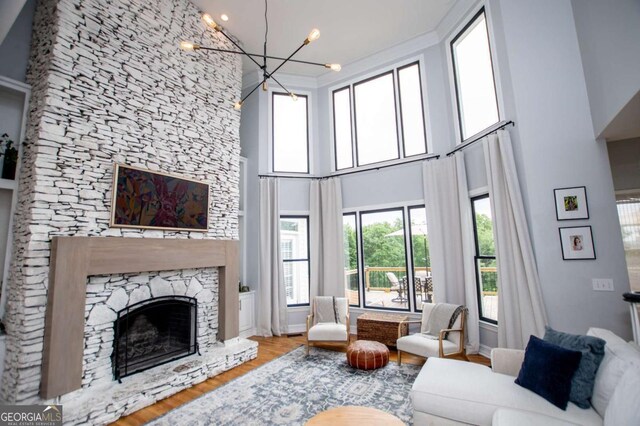 1745 Stripling Chapel Rd, Carrollton, GA 30116 - living room with a high ceiling, a fireplace, a chandelier, baseboards, and wood finished floors