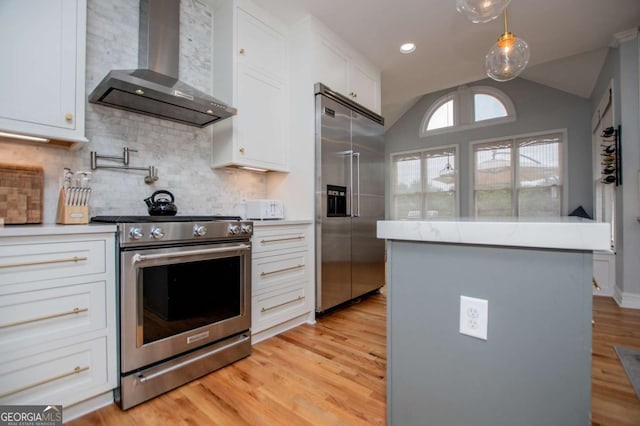 1745 Stripling Chapel Rd, Carrollton, GA 30116 - kitchen with wall chimney range hood, stainless steel appliances, white cabinets, and vaulted ceiling