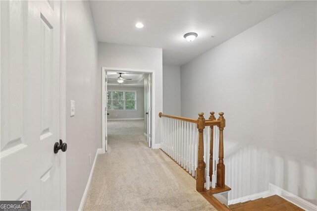 corridor featuring baseboards, recessed lighting, an upstairs landing, and light colored carpet