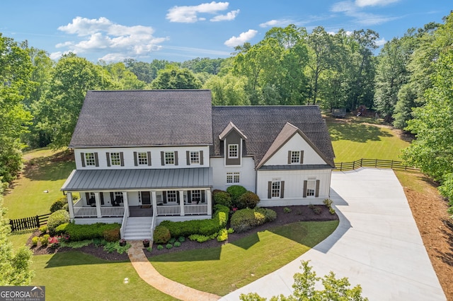 view of front of house with a porch, a front lawn, fence, and concrete driveway