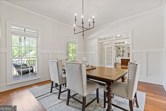 dining space featuring visible vents, wainscoting, and a decorative wall