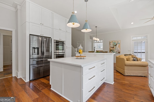 kitchen featuring dark wood-style flooring, open floor plan, light countertops, white cabinets, and appliances with stainless steel finishes