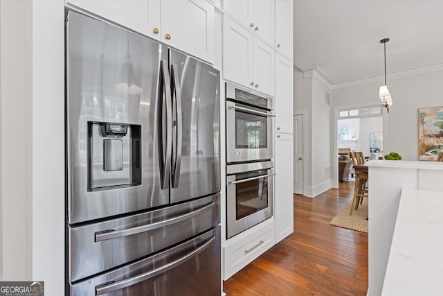 kitchen featuring crown molding, pendant lighting, white cabinets, dark wood-style floors, and stainless steel appliances