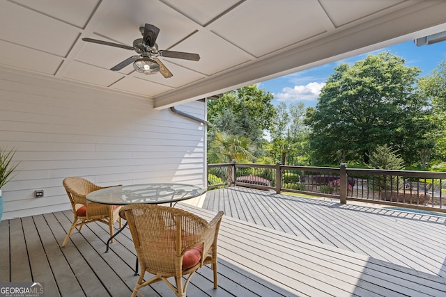 wooden terrace with a ceiling fan and outdoor dining space
