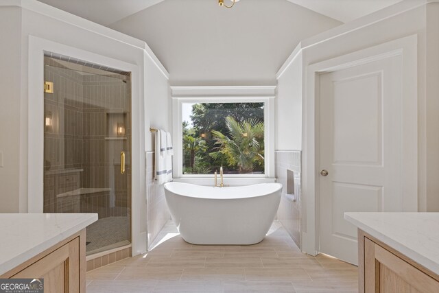 bathroom with a freestanding tub, a shower stall, and vanity