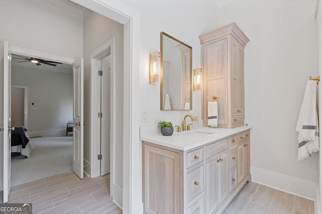 ensuite bathroom with crown molding, connected bathroom, vanity, baseboards, and wood tiled floor