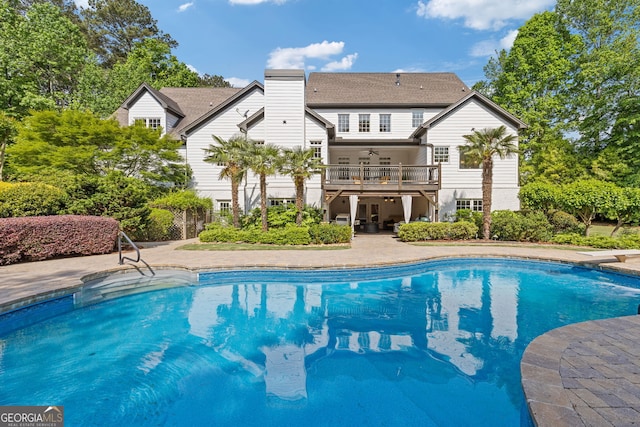 pool featuring a diving board, a ceiling fan, and a patio area