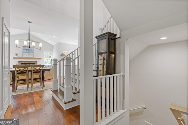 stairway with recessed lighting, a fireplace, lofted ceiling, and hardwood / wood-style flooring
