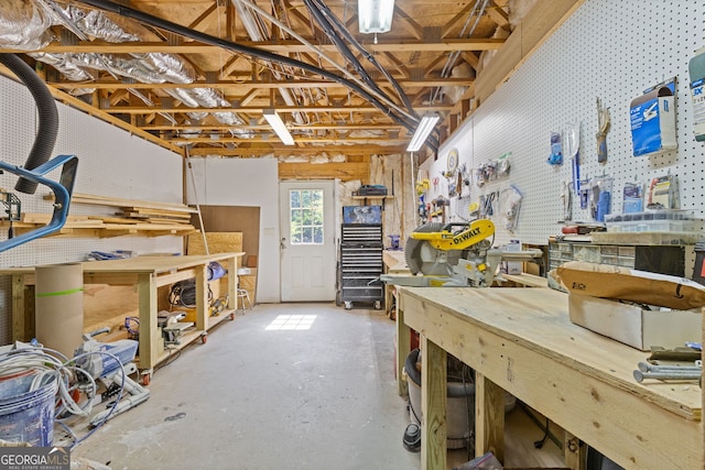 miscellaneous room with a workshop area and unfinished concrete floors
