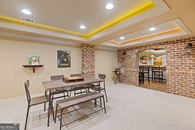 dining space with crown molding, carpet floors, visible vents, a raised ceiling, and arched walkways