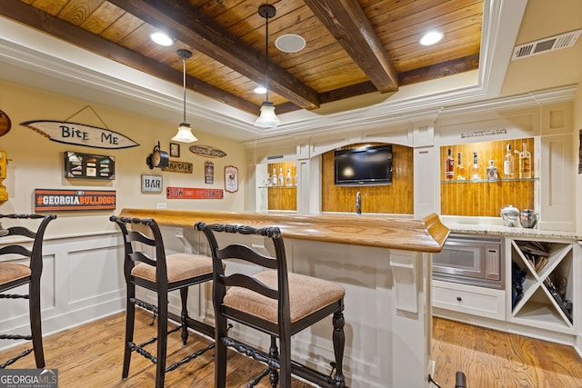 bar featuring visible vents, light wood-type flooring, wood ceiling, stainless steel microwave, and wet bar