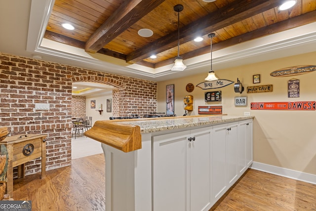 kitchen with a peninsula, brick wall, light stone countertops, wooden ceiling, and light wood-style flooring