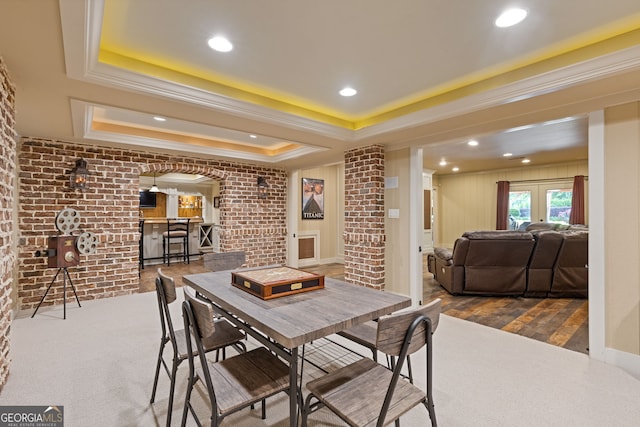 dining area featuring crown molding, brick wall, recessed lighting, a tray ceiling, and arched walkways