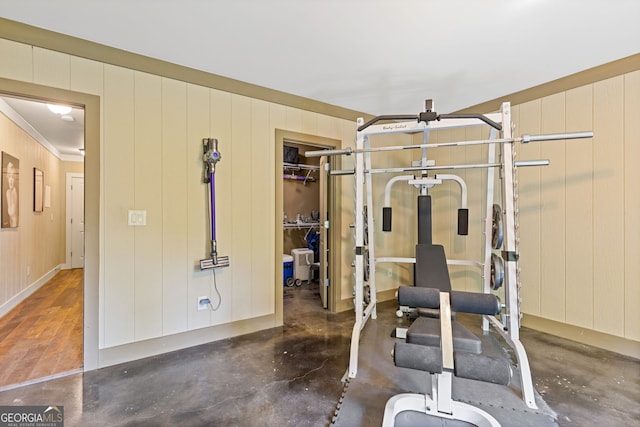 workout room featuring a ceiling fan and ornamental molding