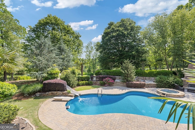 outdoor pool featuring a water slide, an in ground hot tub, and a patio area