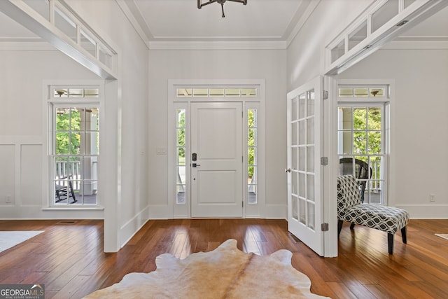 foyer entrance with wood-type flooring, french doors, plenty of natural light, and ornamental molding