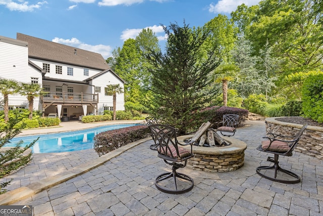 outdoor pool with a patio and a fire pit