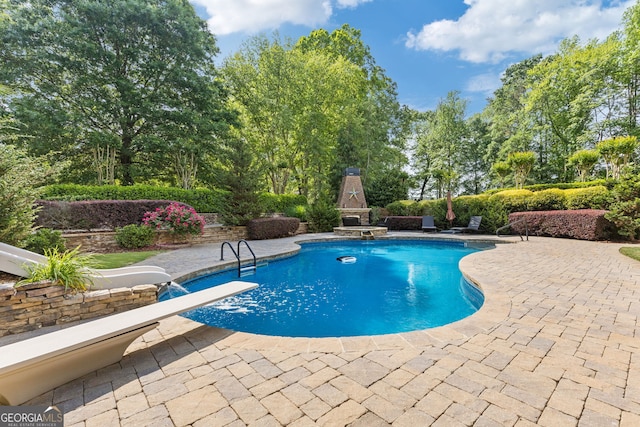 pool featuring a diving board and a patio area
