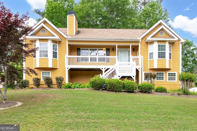 view of front of house featuring covered porch, stairway, a chimney, and a front lawn