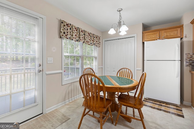 dining area featuring light tile patterned floors, baseboards, and a chandelier