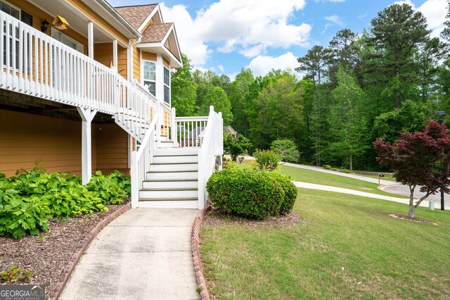 view of home's community with a lawn and stairs