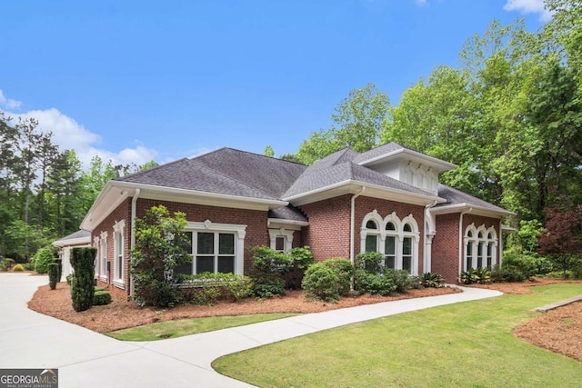view of front facade featuring a front yard and brick siding
