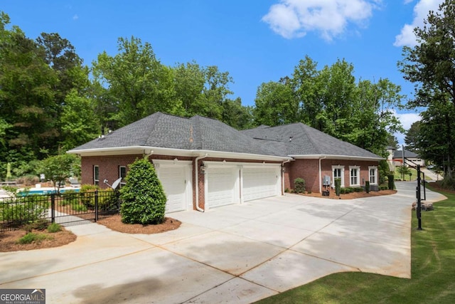view of front of house with a garage, brick siding, fence, concrete driveway, and a shingled roof