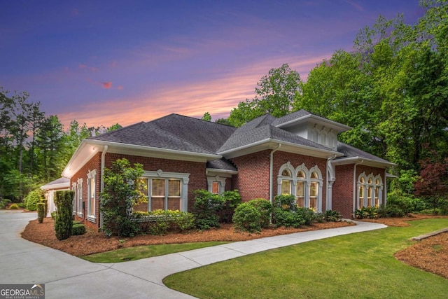 view of front of home with brick siding and a front lawn