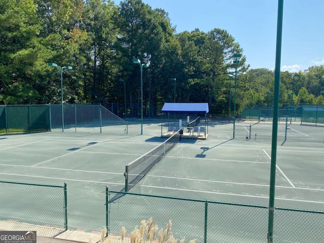 view of tennis court featuring fence