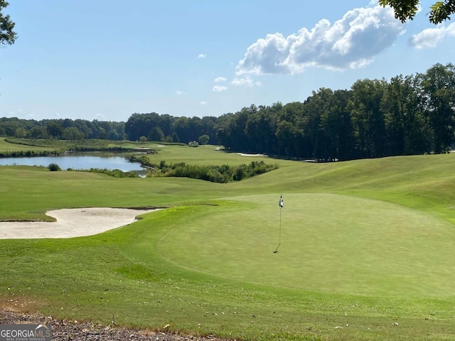 view of home's community featuring a lawn, a water view, and golf course view
