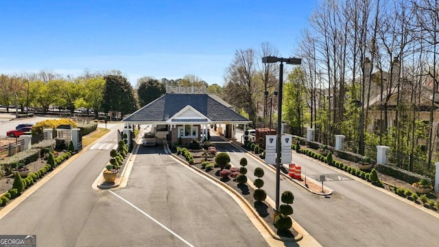 view of front facade with an attached carport, fence, and aphalt driveway