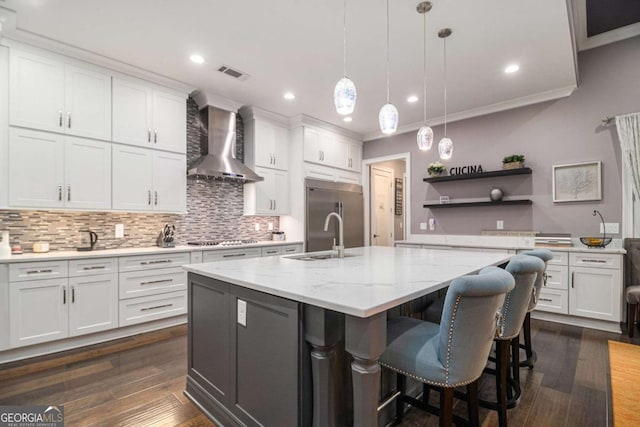 kitchen with open shelves, appliances with stainless steel finishes, a sink, wall chimney exhaust hood, and visible vents
