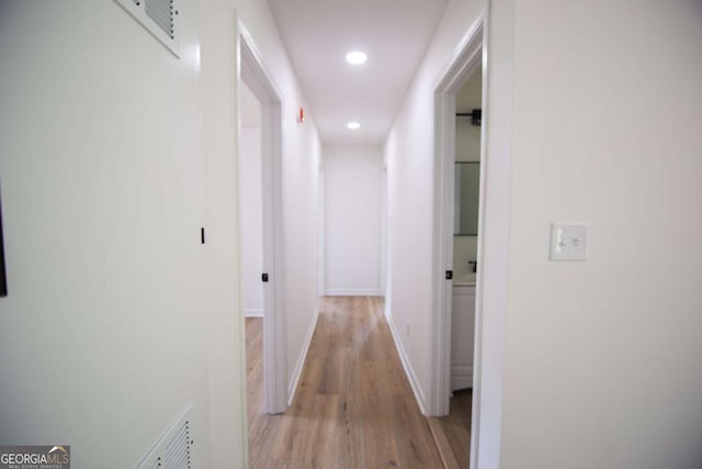 hall with recessed lighting, baseboards, and light wood finished floors