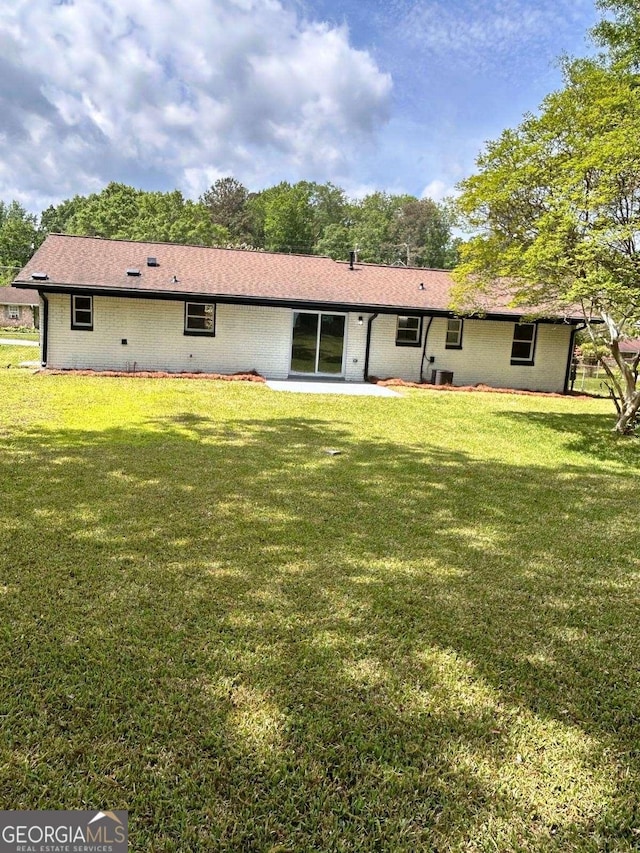 back of property with a lawn and a patio area