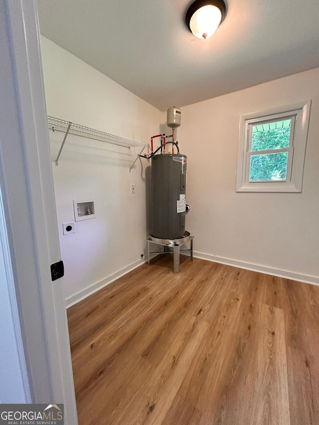 4074 Green Hawk Trl, Decatur, GA 30035 - washroom featuring water heater, electric dryer hookup, hookup for a washing machine, light wood finished floors, and baseboards