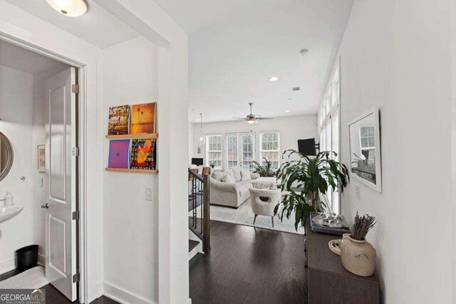 hall with recessed lighting, baseboards, an upstairs landing, and dark wood-type flooring