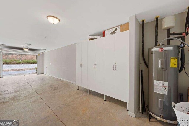garage with baseboards and water heater
